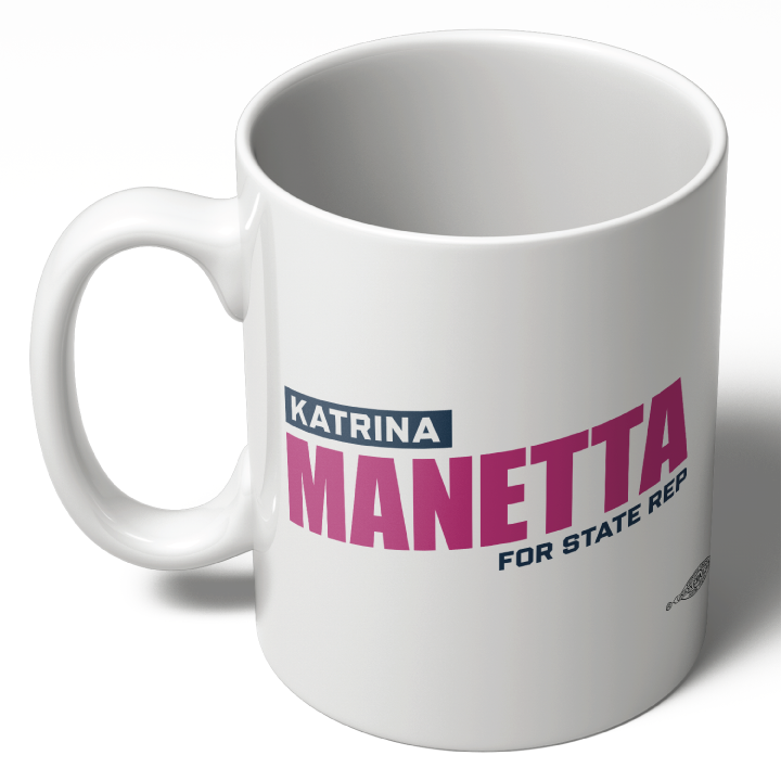 کوپەی سێرامیکی سپی کە ناوی "Katrina Manetta" بە پیتی پەمەیی گەورە لەسەریەتی، لەگەڵ دەستەواژەی "FOR STATE REP" بە پیتی شینی بچووکتر لە خوارەوە. کوپەکە دەستەیەکی ئاسایی و ڕوویەکی نەرم هەیە.