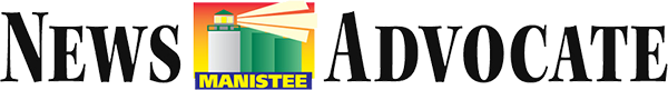 A News Advocate masthead with a multicolored house logo and the word MANISTEE between the title words on a black background.